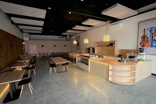 The cafe in the evening with pendant lights on and the oak counter glowing from beneath
